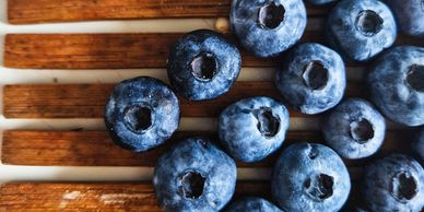 Close-up of fresh blueberries on a wooden surface.