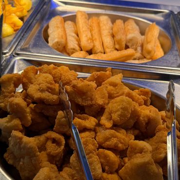 Buffet trays holding fried Chinese donuts and chicken.