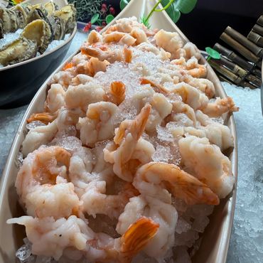 Platter of peeled raw shrimp chilled on a bed of crushed ice.