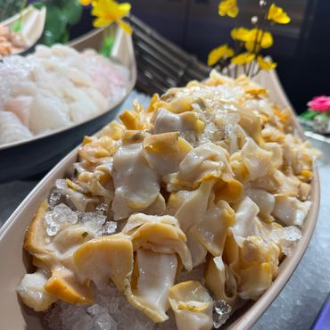 Sliced fresh yellow clam meat served on a bed of crushed ice.