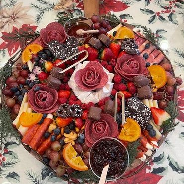 Artfully arranged charcuterie board with meats, cheeses, fruits, and dips on a festive tablecloth.