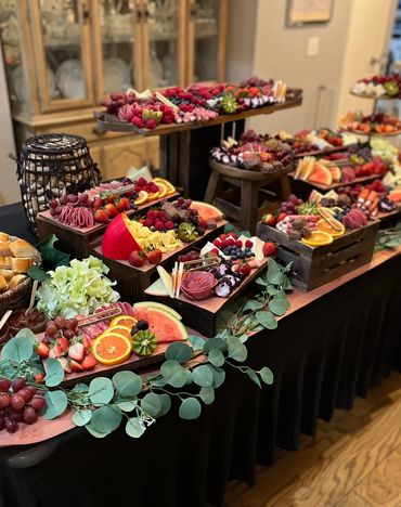 An elegant fruit and charcuterie spread with vibrant colors and greenery accents.