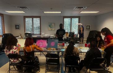 Group of people participating in a painting class in a well-lit room.