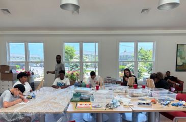 Group of people engaged in a painting activity in a bright room.