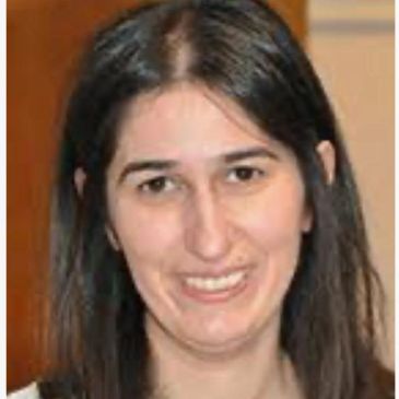 Portrait of a smiling woman with long dark hair.