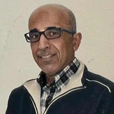 Middle-aged man with glasses and a checkered shirt.