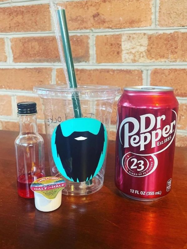 A Dr Pepper can, drink cup, syrup, and seasoning cup.