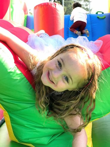 A little girl laying down on a bouncy castle