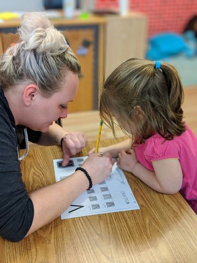 A teacher helping a girl
