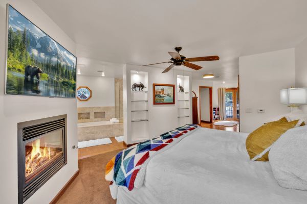 Cozy bedroom with fireplace and nature decor.