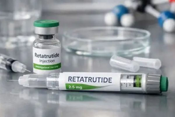 Retatrutide injection vial and syringe on a lab table.