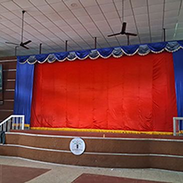 Empty stage with red curtain and blue sides.