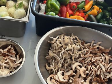 Bowls of chopped mushrooms and vegetables on a table.