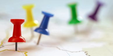Colorful map pins lined up on a map.