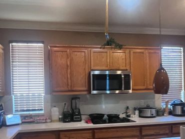 A modern kitchen with wooden cabinets and white marble countertops.