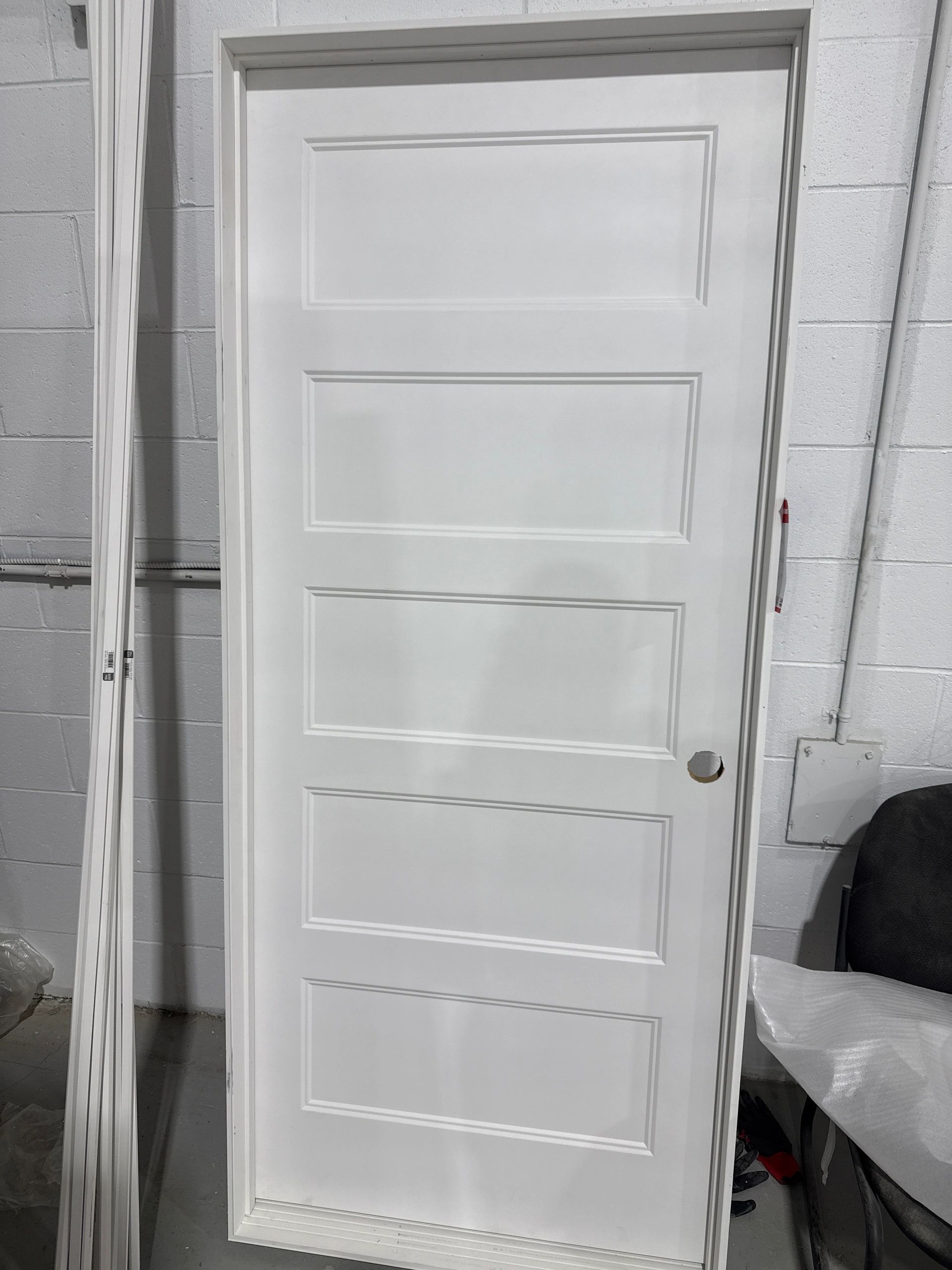 White interior door with rectangular panel design leaning against a wall.