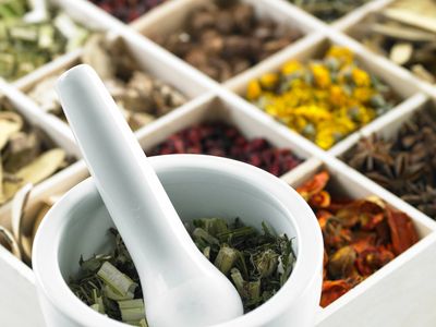 Divided box of herbs with mortar and pestle.