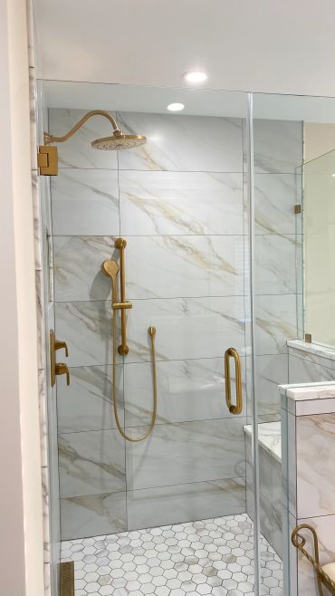 Luxurious bathroom shower with gold fixtures.