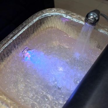 A basin with flowing water and blue LED light inside.