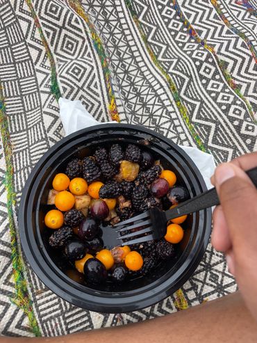 Fruit bowl with blackberries and goldenberries on a patterned surface.