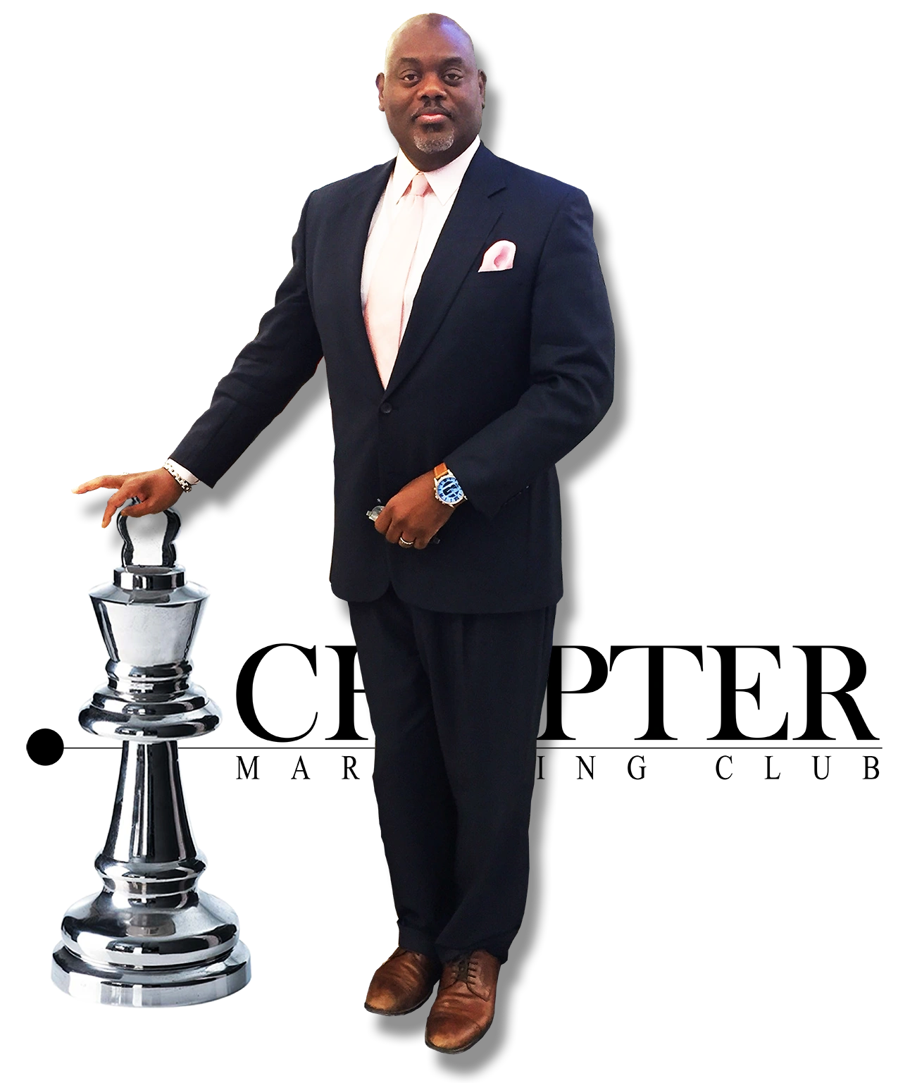 Man in a suit standing next to a large silver chess king piece.