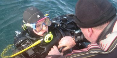 Diver being unkitted in the water