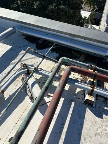 Rusty and weathered pipes on a rooftop.