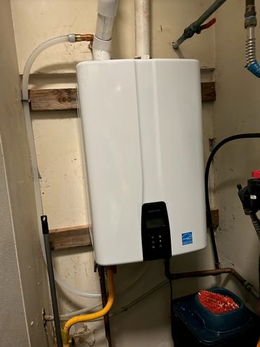 White Navien water heater mounted on wall.