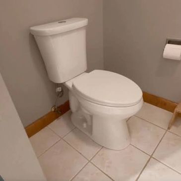 White toilet in a small bathroom corner.