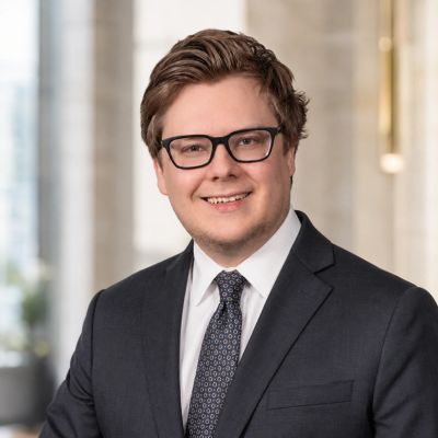 Young man in a suit smiling confidently.