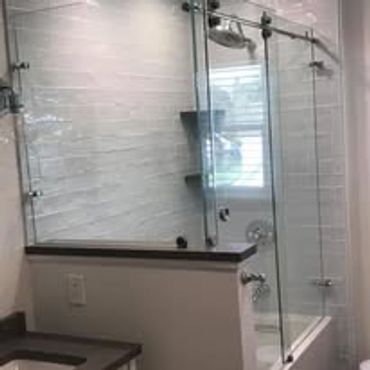 Modern bathroom with glass shower enclosure and white subway tiles.
