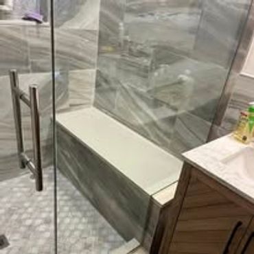 Modern bathroom with glass shower and rectangular bathtub.