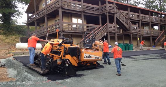 Paving Crew installing asphalt with a paving machine on a newly subgraded parking lot.