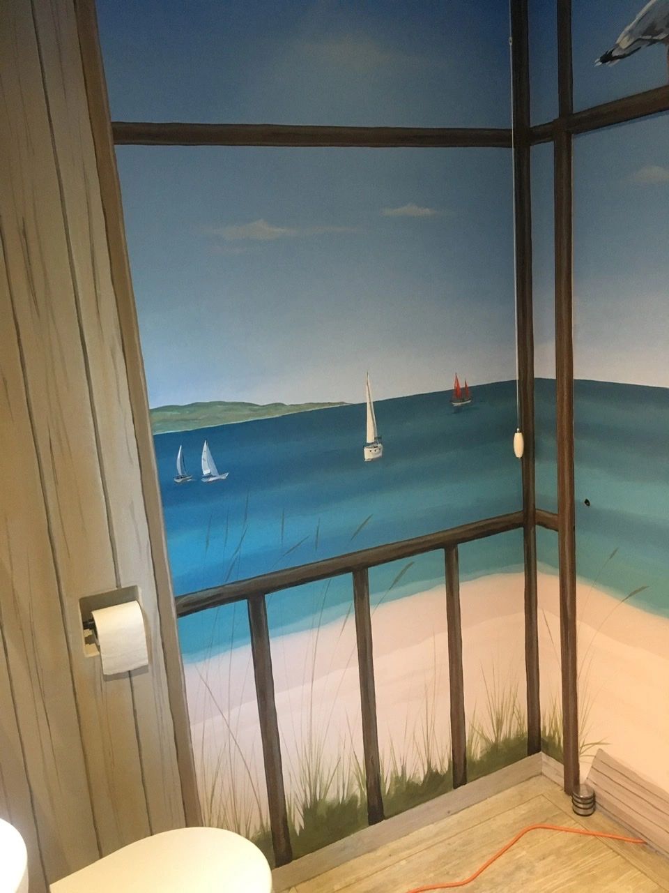 A bathroom painted up in a beach theme.