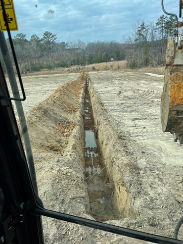 Long freshly dug trench in a new field for irrigation.