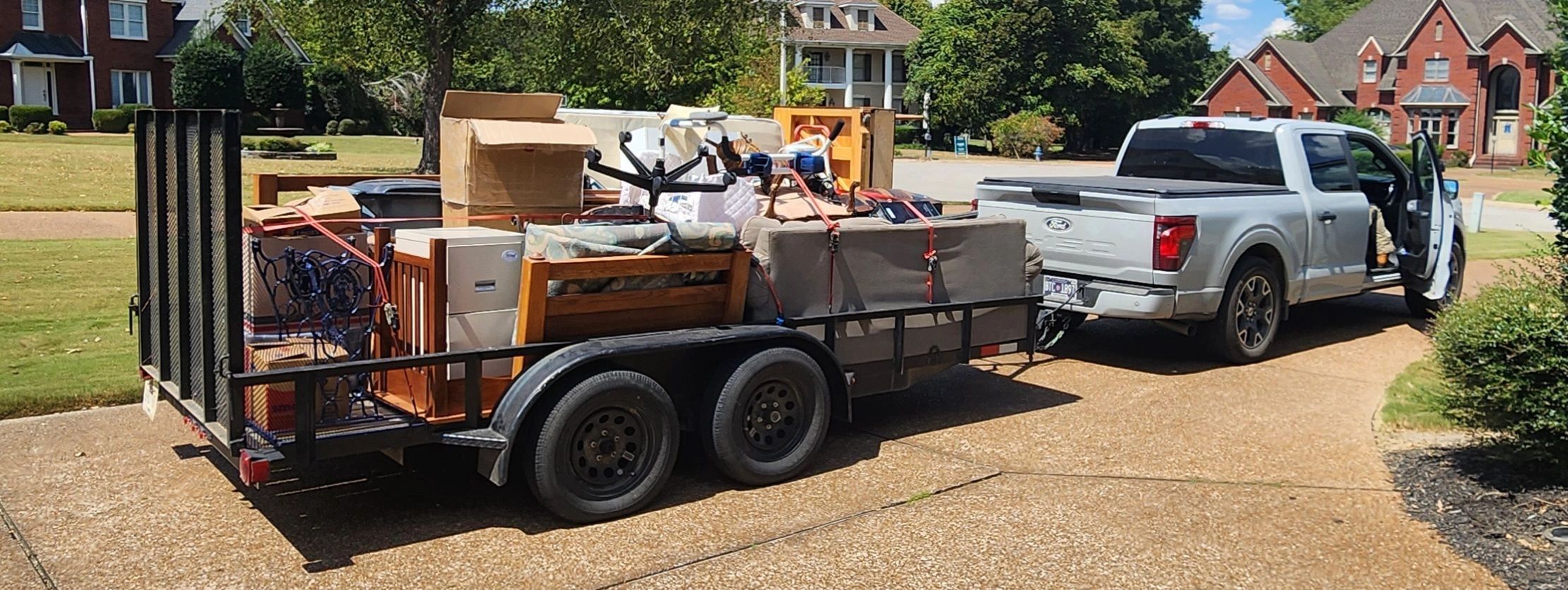 Pickup truck towing a loaded furniture trailer.