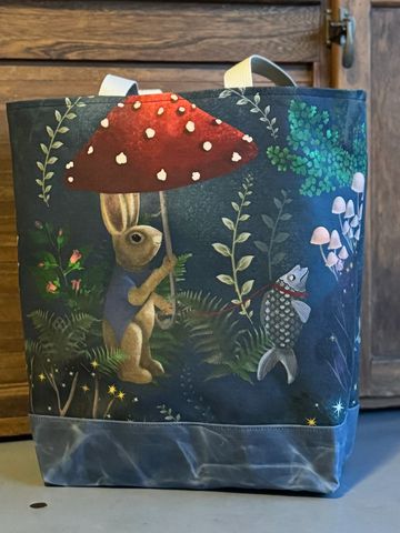 A bag with a whimsical rabbit and fish design under a mushroom umbrella.