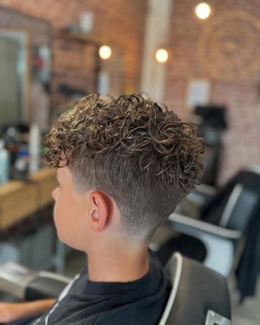 Curly hair fade haircut in a barbershop.
