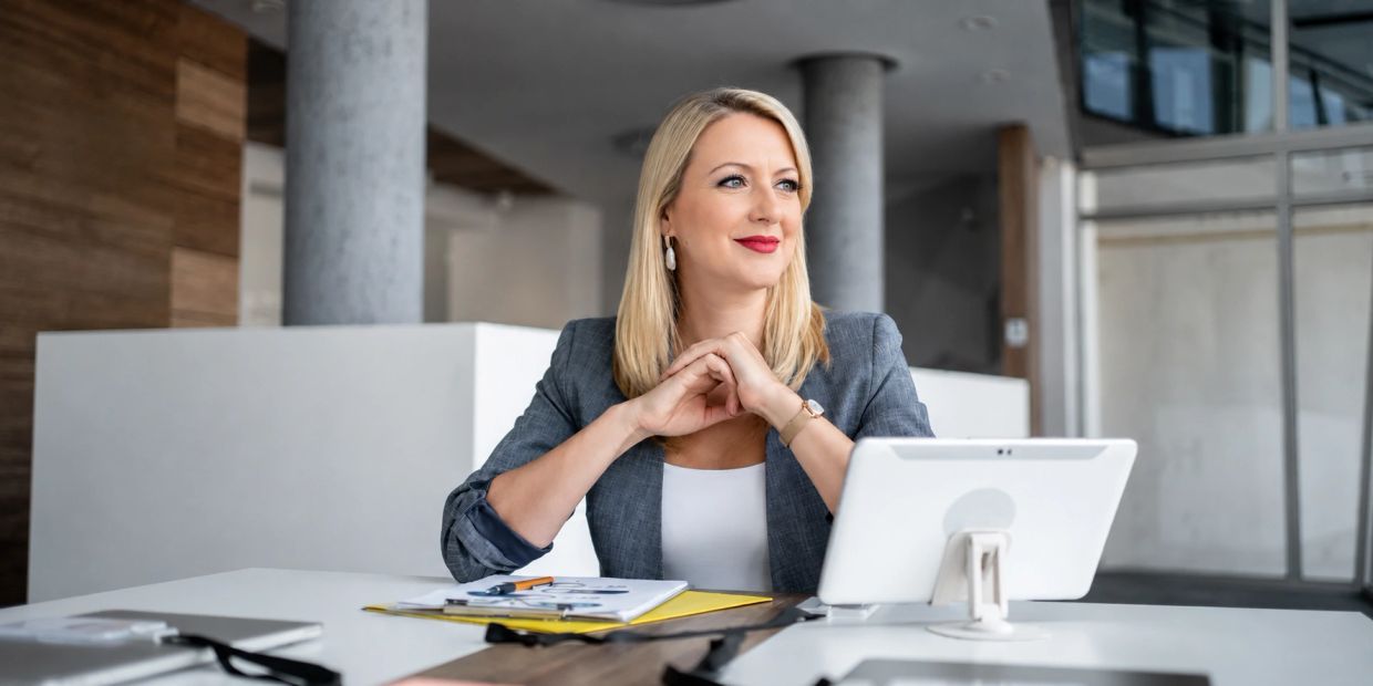 Businesswoman in office looking thoughtfully.