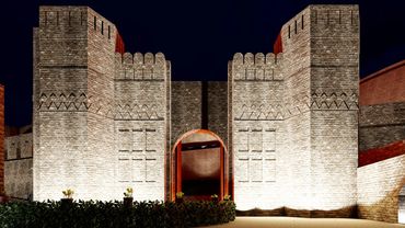 Illuminated fortress at night, showcasing its imposing walls and structures against a dark sky.