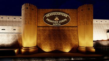 Illuminated fortress at night, showcasing its imposing walls and structures against a dark sky.