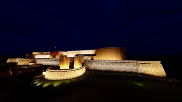 Illuminated fortress at night, showcasing its imposing walls and structures against a dark sky.