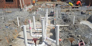 Construction site with plumbing pipes being installed.
