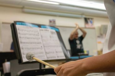 Drum student playing marimba with mallets while being conducted by Jim Mola. www.brooklynacademyofpe