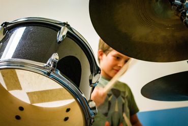 A young drum student practicing his drum set lesson that he was given at Drum Camp.