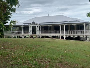 Large vintage-style house with a wraparound porch.