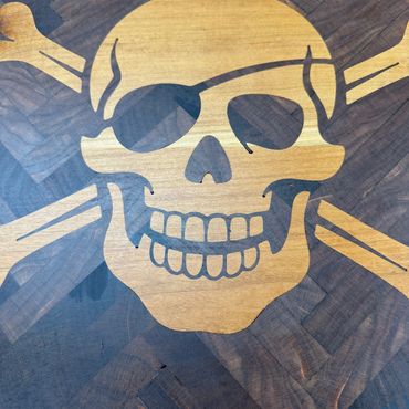 Wooden pirate skull and crossbones inlay with an eye patch.