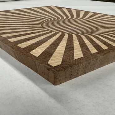 Wooden panel with a geometric spiral pattern in contrasting shades.