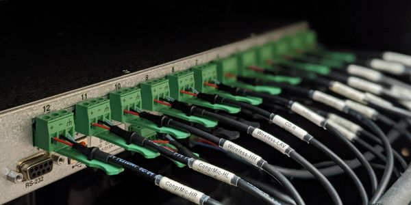 Wires neatly labeled, going into a digital audio mixer