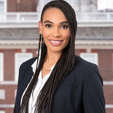 Founder. Woman with braids and suit jacket.